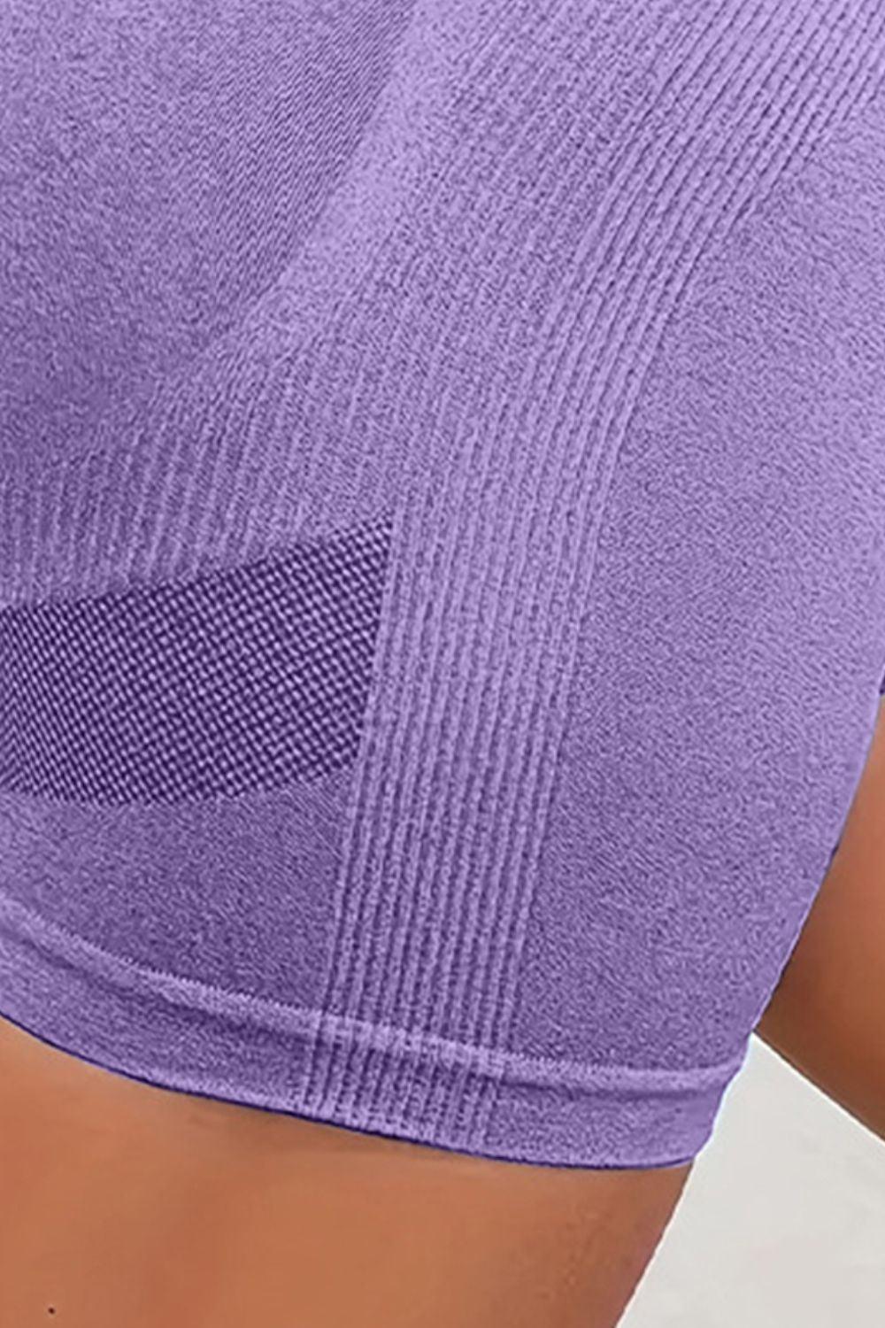 a close up of a person wearing a purple sports bra