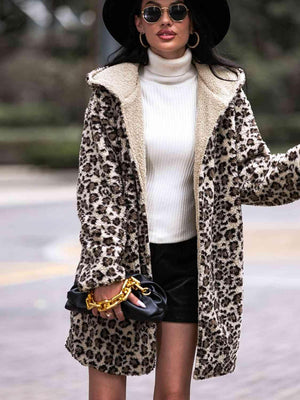 a woman wearing a leopard print coat and black hat