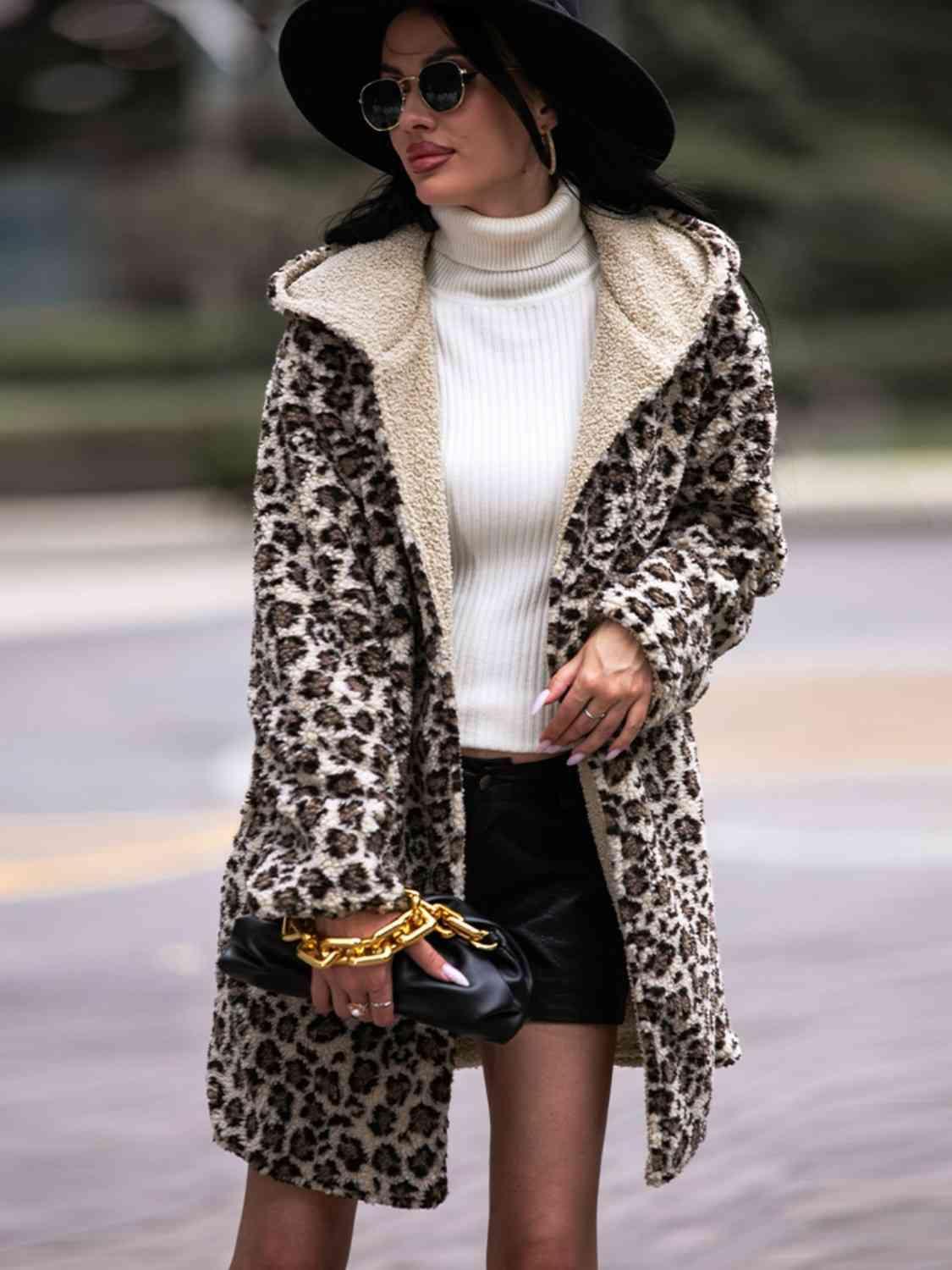 a woman wearing a leopard print coat and black hat