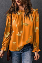 a woman wearing an orange top with elephants on it