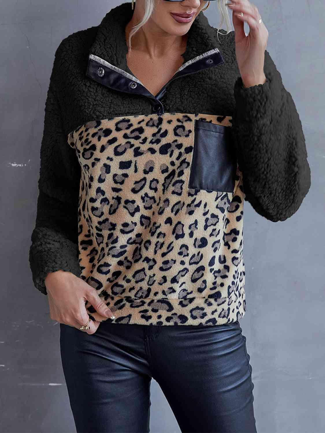 a woman wearing a leopard print shirt and black jeans