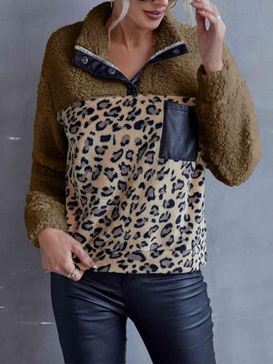 a woman wearing a leopard print shirt and black pants