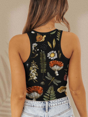 a woman wearing a black tank top with flowers and leaves on it