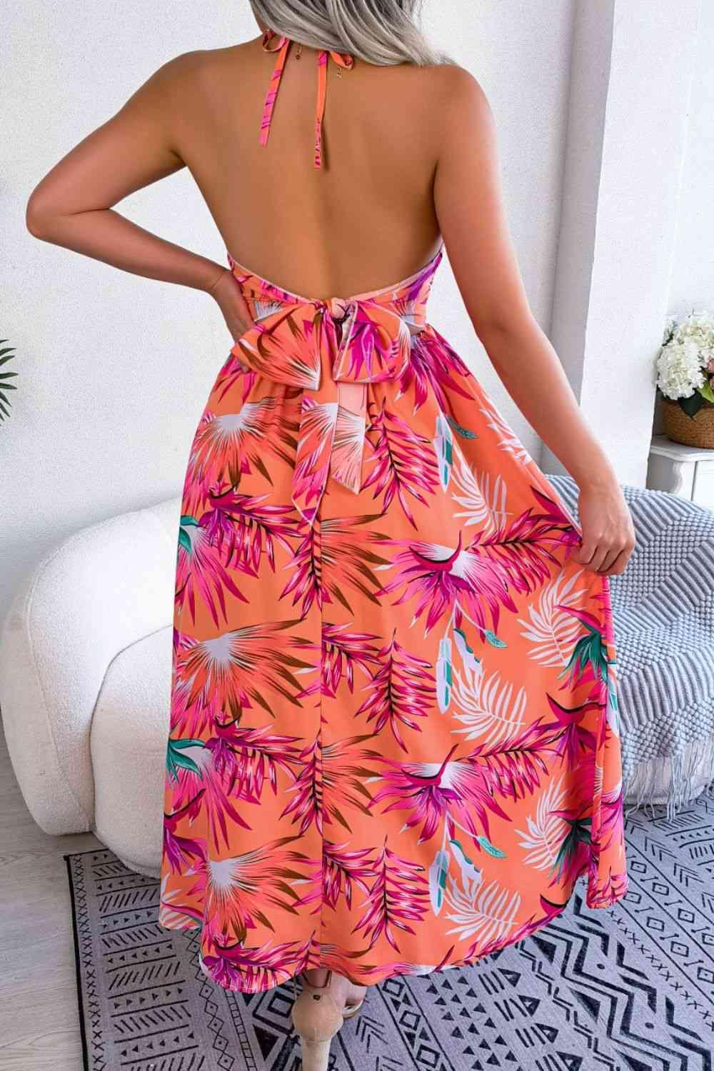the back of a woman wearing a pink tropical print dress