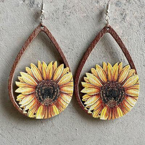 a pair of earrings with a sunflower painted on them