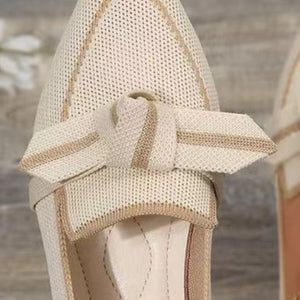 a close up of a pair of shoes with a bow