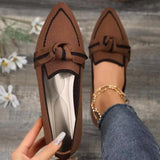 a woman's hand holding a pair of brown shoes