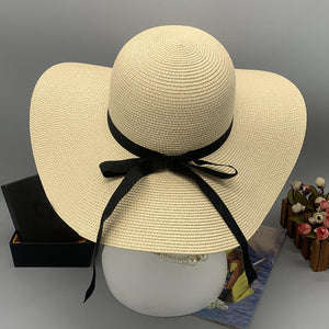 a white hat with a black ribbon tied around it