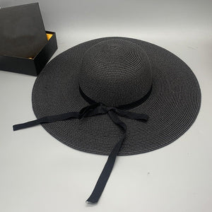 a black hat with a black ribbon around the brim