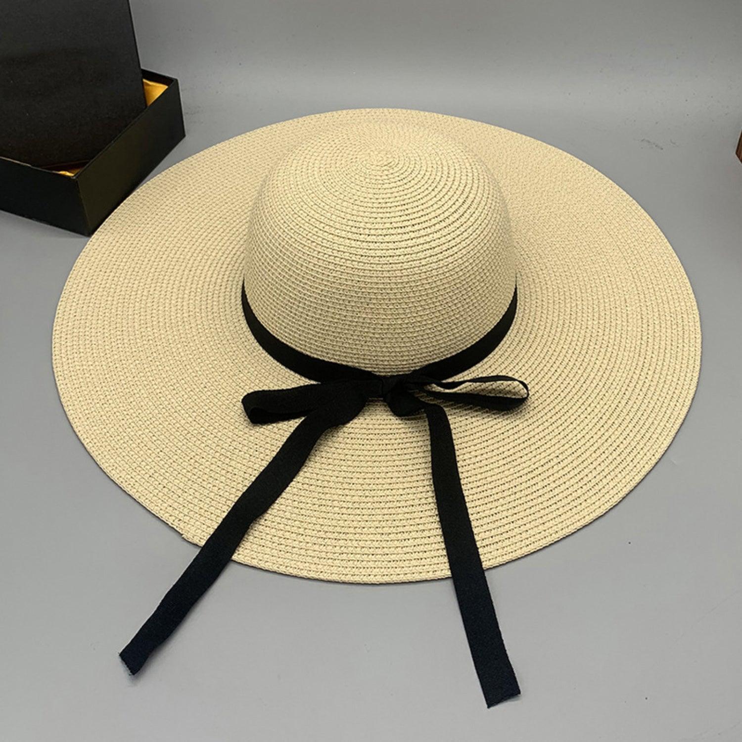 a white hat with a black ribbon tied around it
