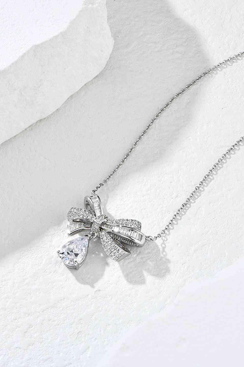 a necklace with a bow and a diamond