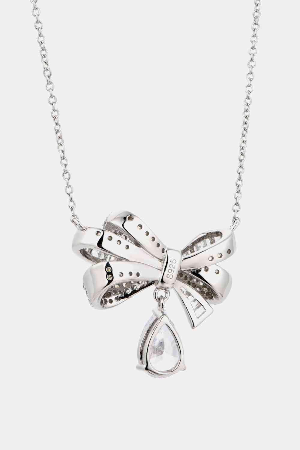 a silver necklace with a bow on it