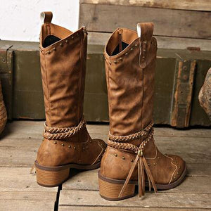 a pair of brown boots with tassels on them