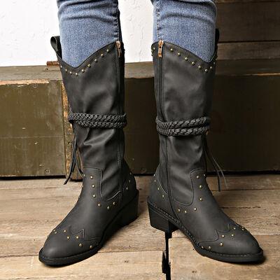 a pair of black boots with gold studs on them
