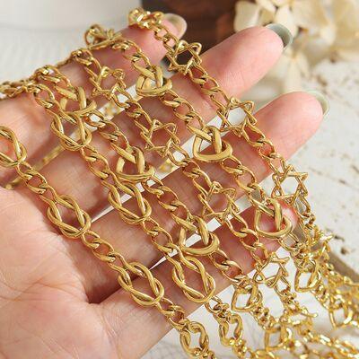 a hand holding a gold chain on top of a table