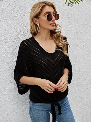 a woman wearing a black sweater and sunglasses