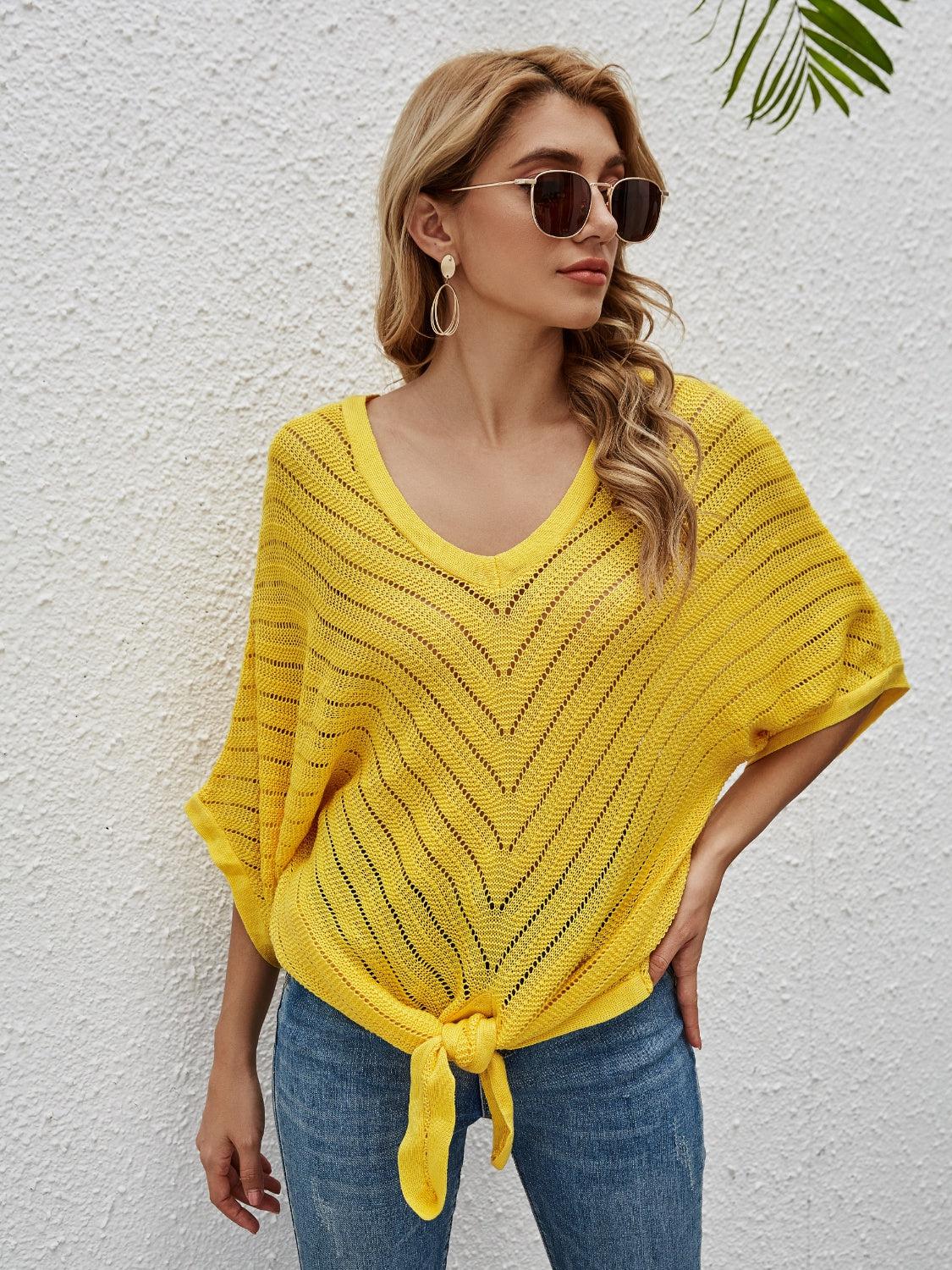 a woman wearing a yellow sweater and sunglasses