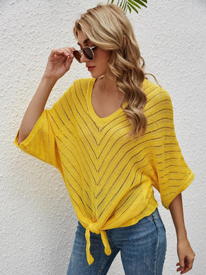 a woman wearing a yellow sweater and sunglasses