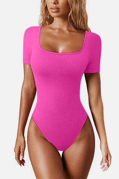 a woman in a pink bodysuit