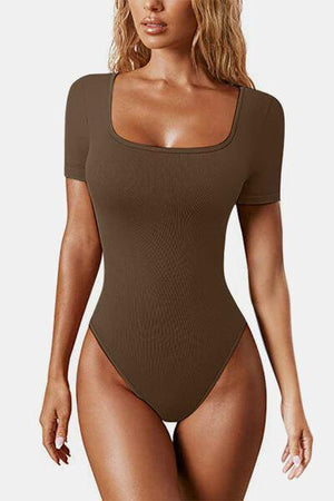 a woman in a brown bodysuit
