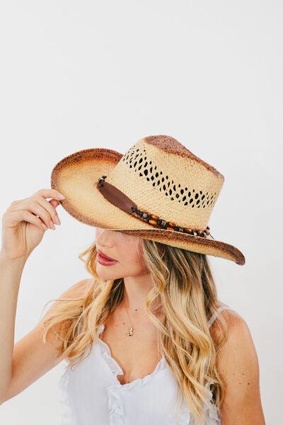 a woman wearing a straw hat and a white top