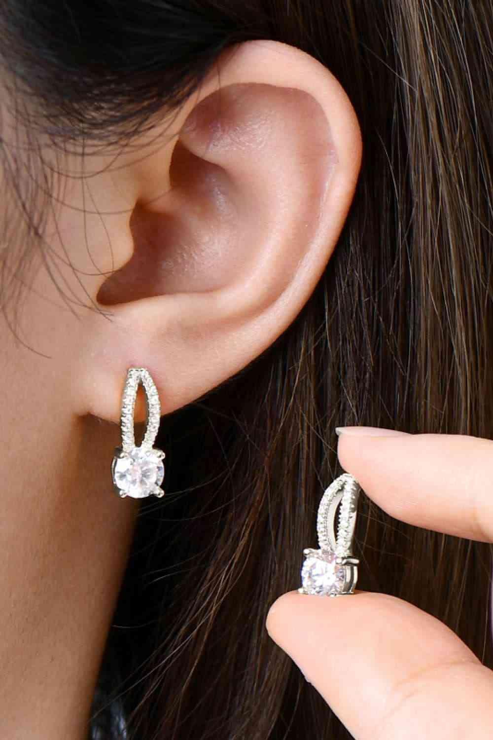 a close up of a person wearing a pair of earrings