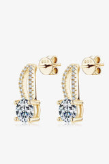 a pair of gold earrings with a cubic stone