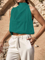 a woman wearing a green top and white pants