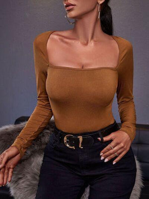 a woman wearing a brown top and black pants