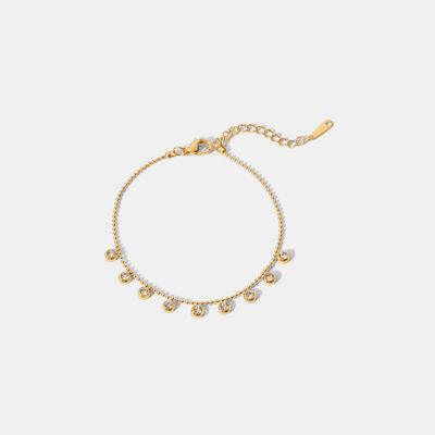a gold bracelet with pearls on a white background