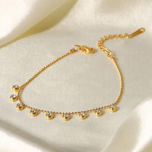 a gold bracelet on a white cloth