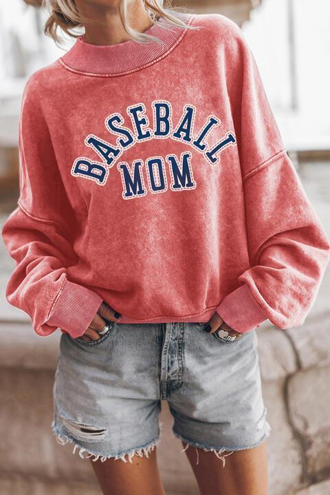 a woman wearing a baseball mom sweatshirt