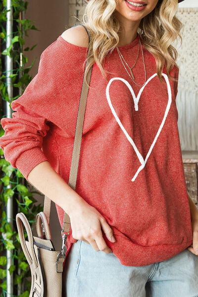 a woman wearing a red sweater with a heart drawn on it
