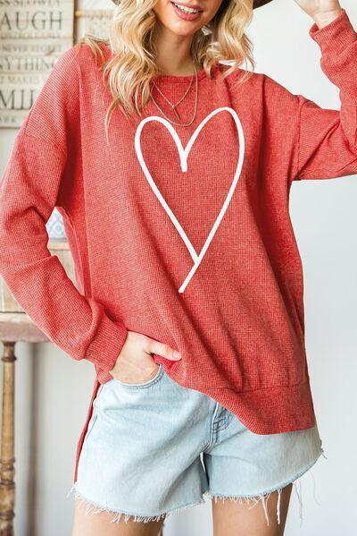 a woman wearing a red sweater with a heart on it