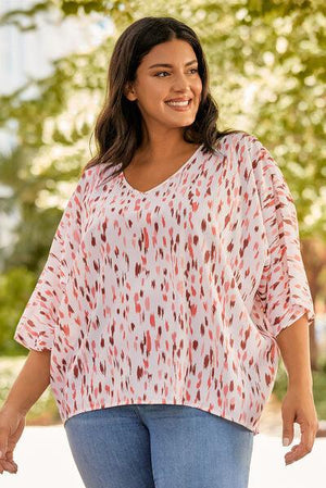 a woman in a white and red top smiles