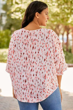 a woman wearing a white top with red spots