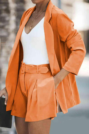 a woman wearing an orange blazer and shorts
