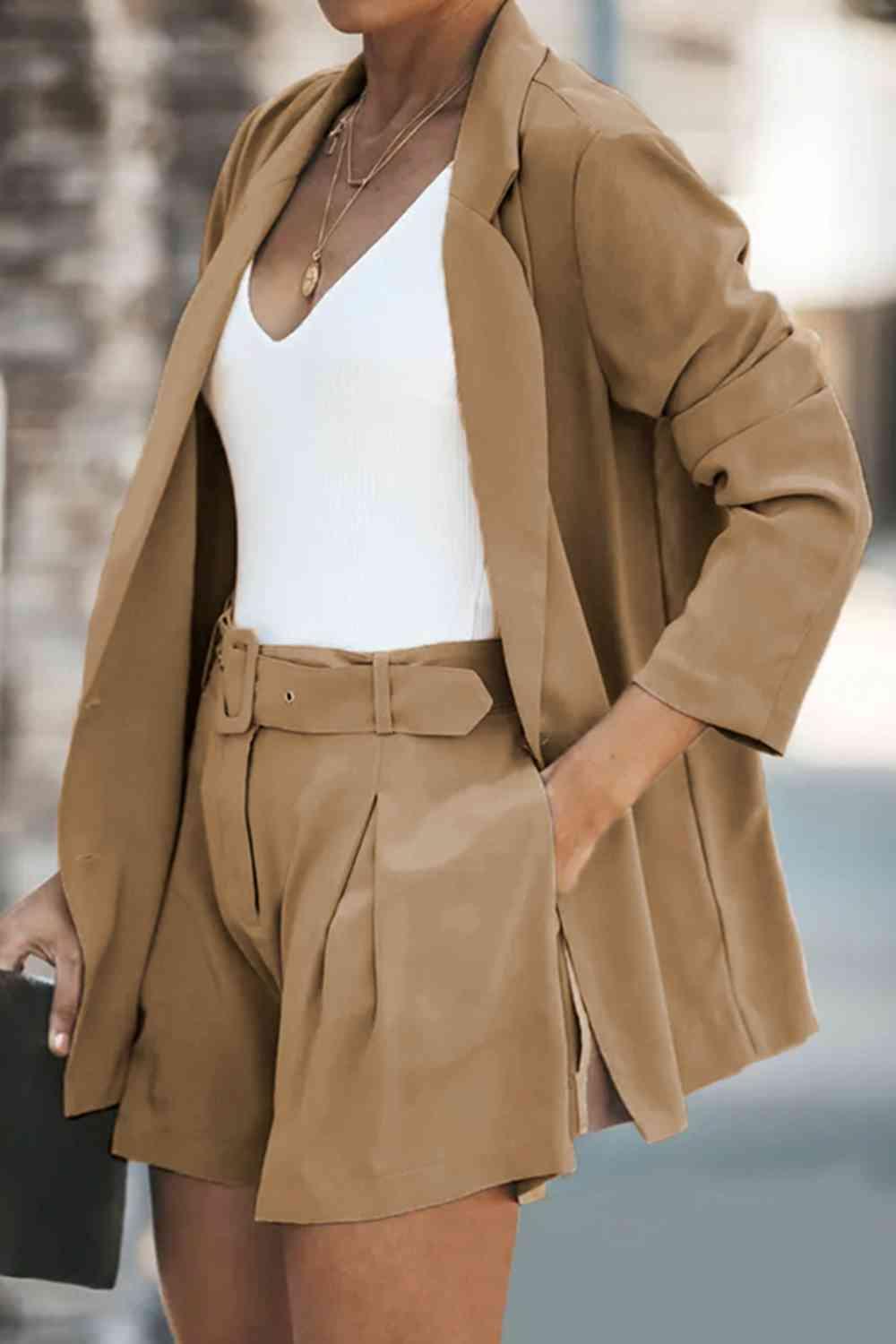 a woman wearing a tan jacket and shorts