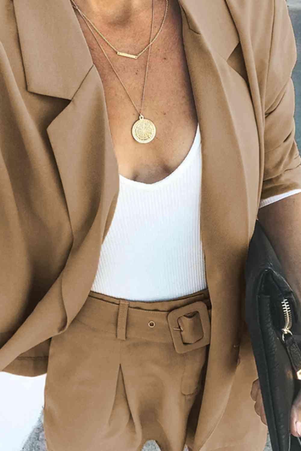 a woman wearing a tan blazer and tan pants