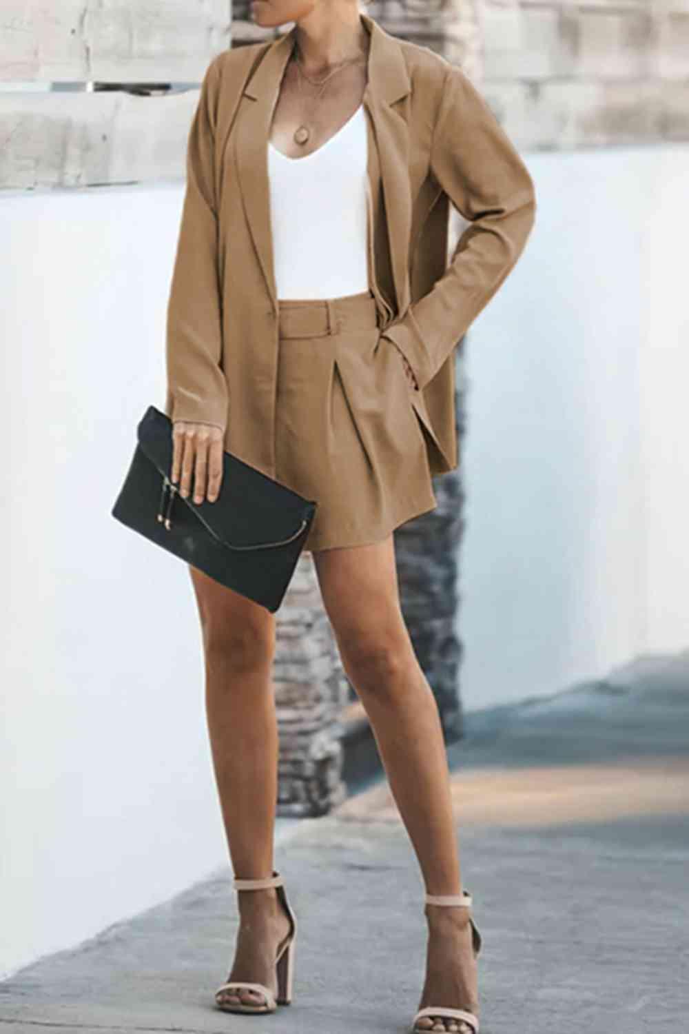 a woman wearing a tan suit and heels