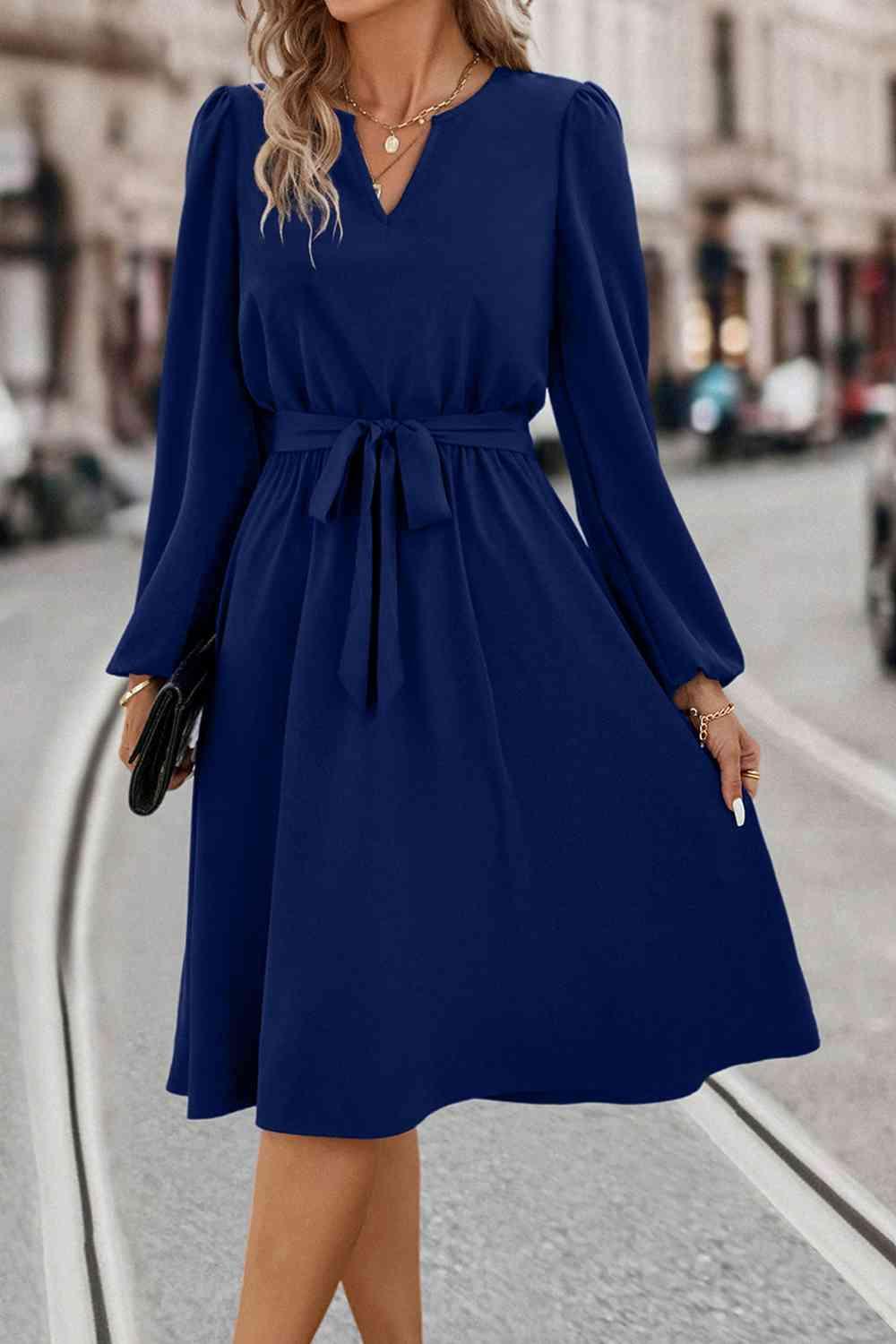 a woman in a blue dress is walking down the street