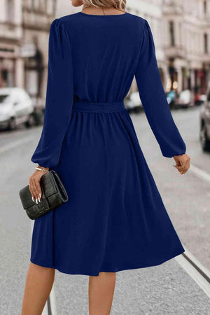 a woman in a blue dress is walking down the street