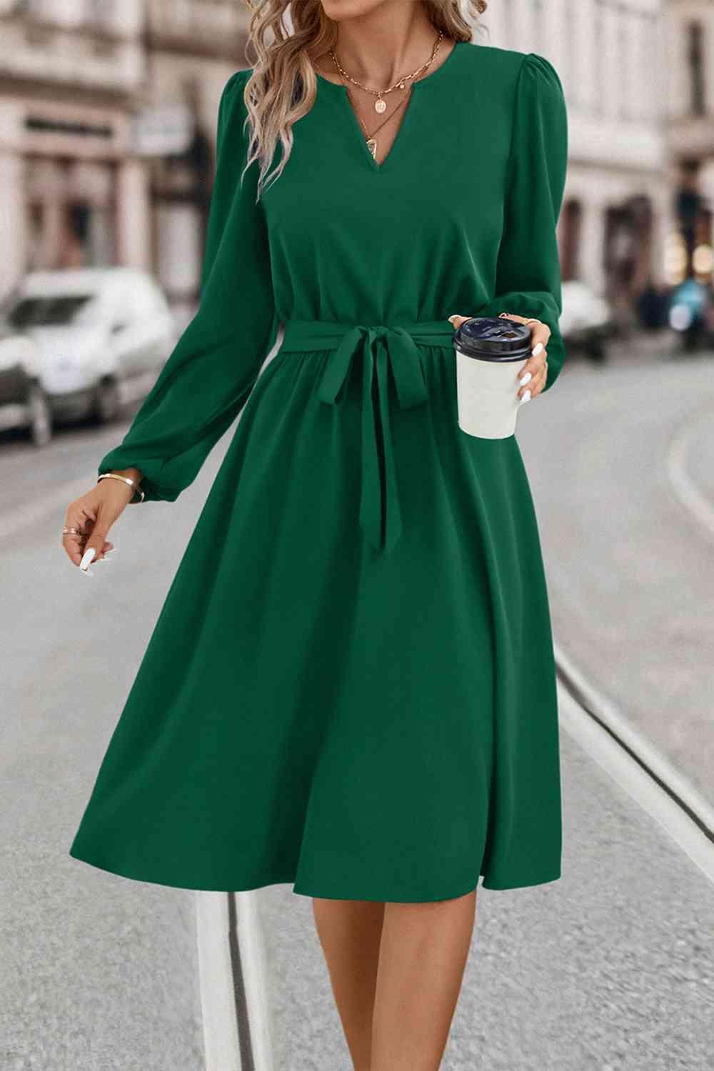 a woman in a green dress holding a cup of coffee