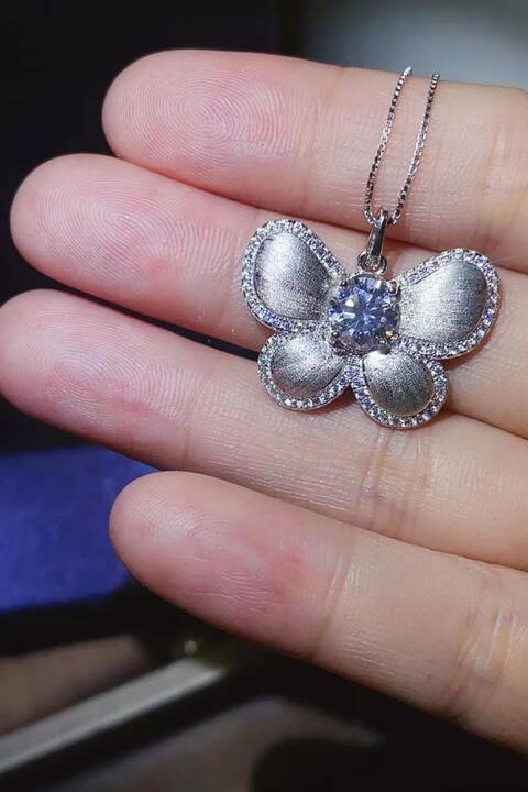 a person is holding a silver flower necklace