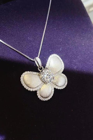 a necklace with a flower and a diamond on it