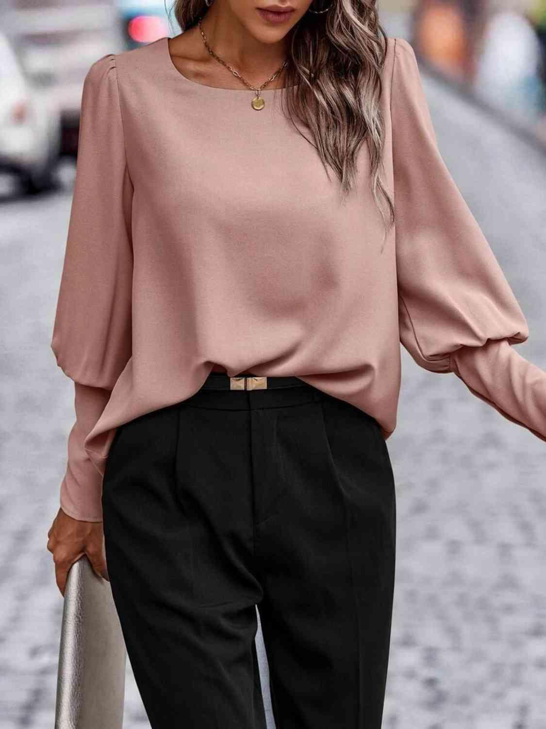 a woman wearing a pink top and black pants