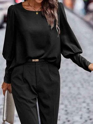 a woman wearing a black top and pants