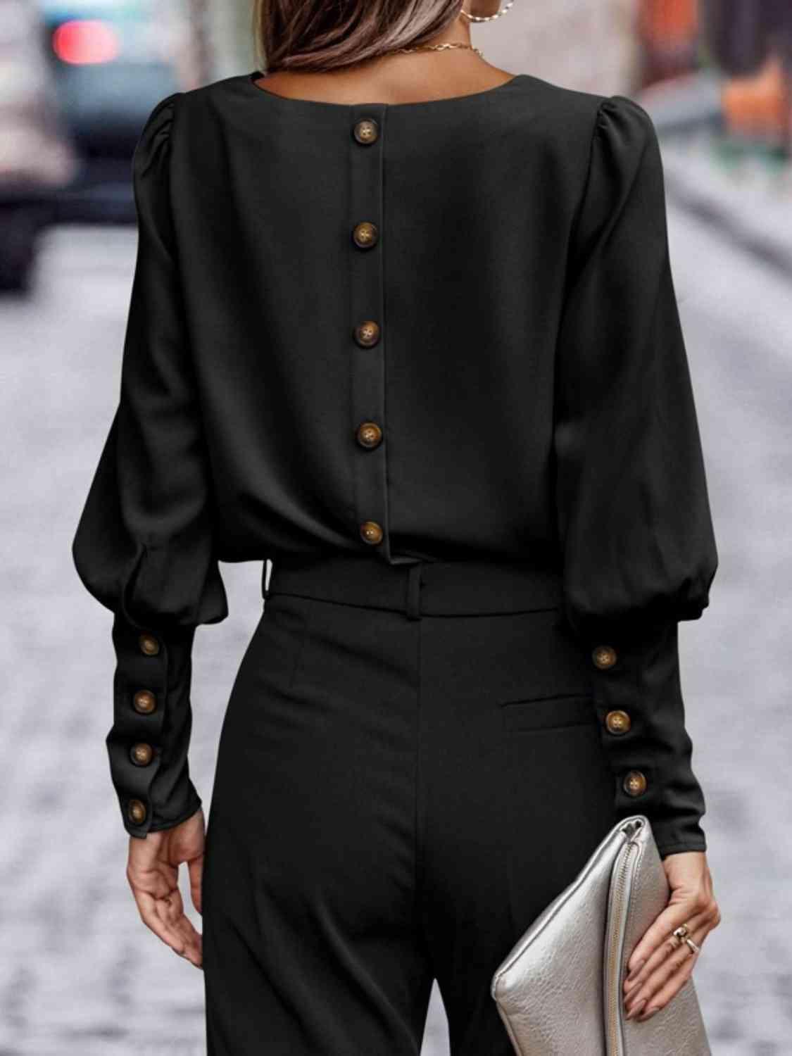 a woman wearing a black jumpsuit with buttons