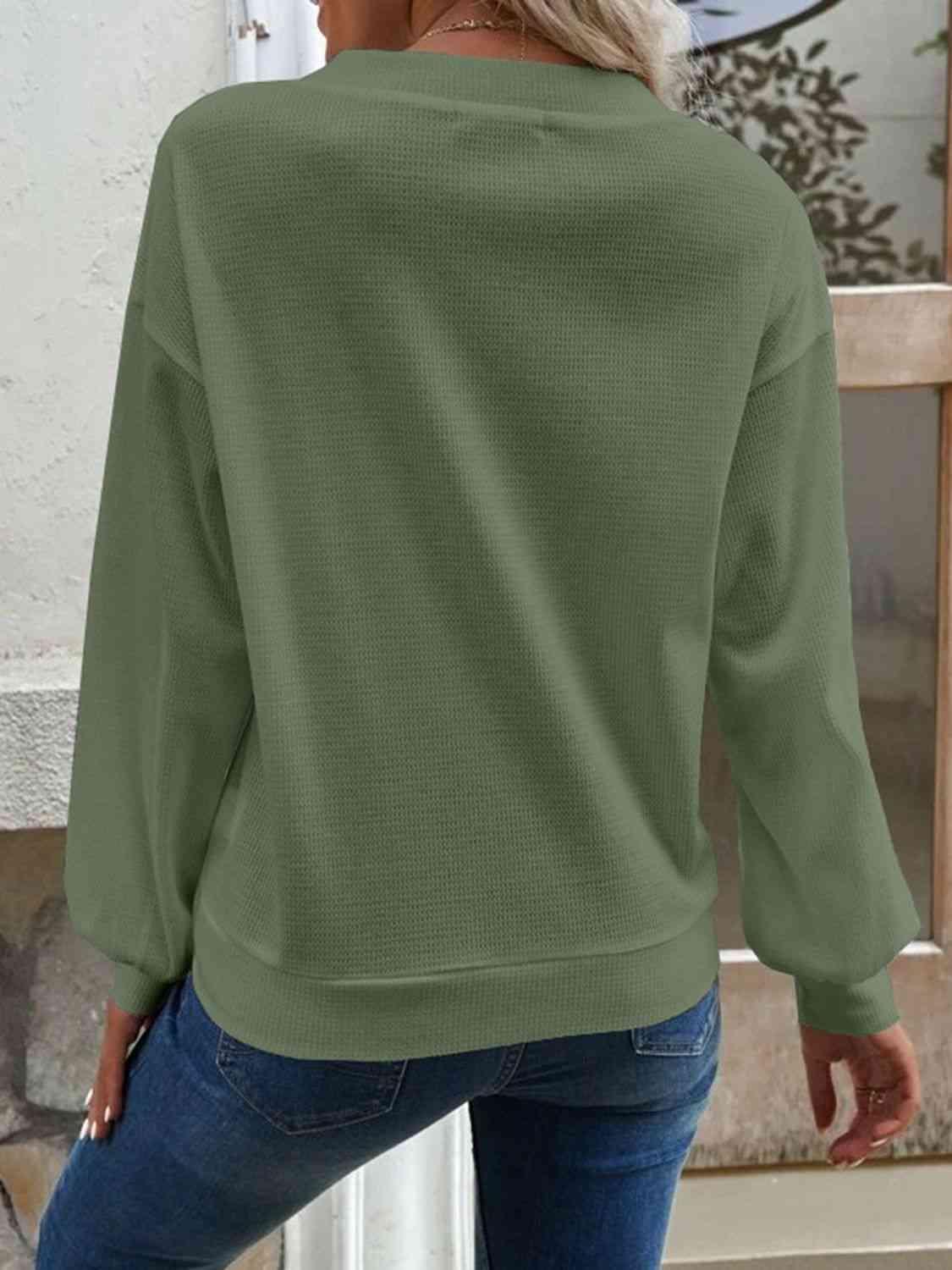 a woman wearing a green sweater and jeans