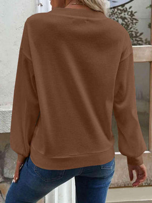 a woman wearing a brown sweater and jeans